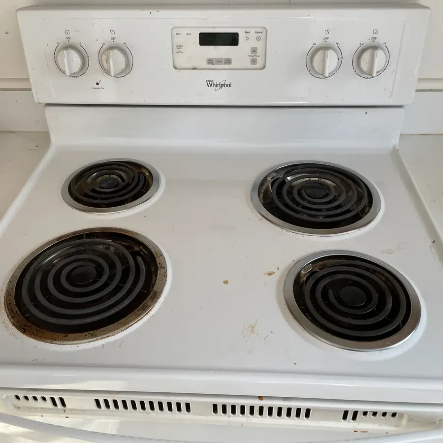an electric stovetop and burners, before a Brio Cleaning visit