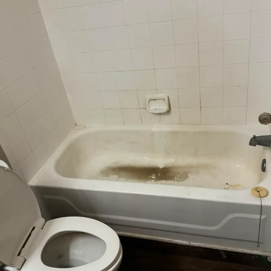 a bathtub and tiled surround, before a Brio Cleaning visit