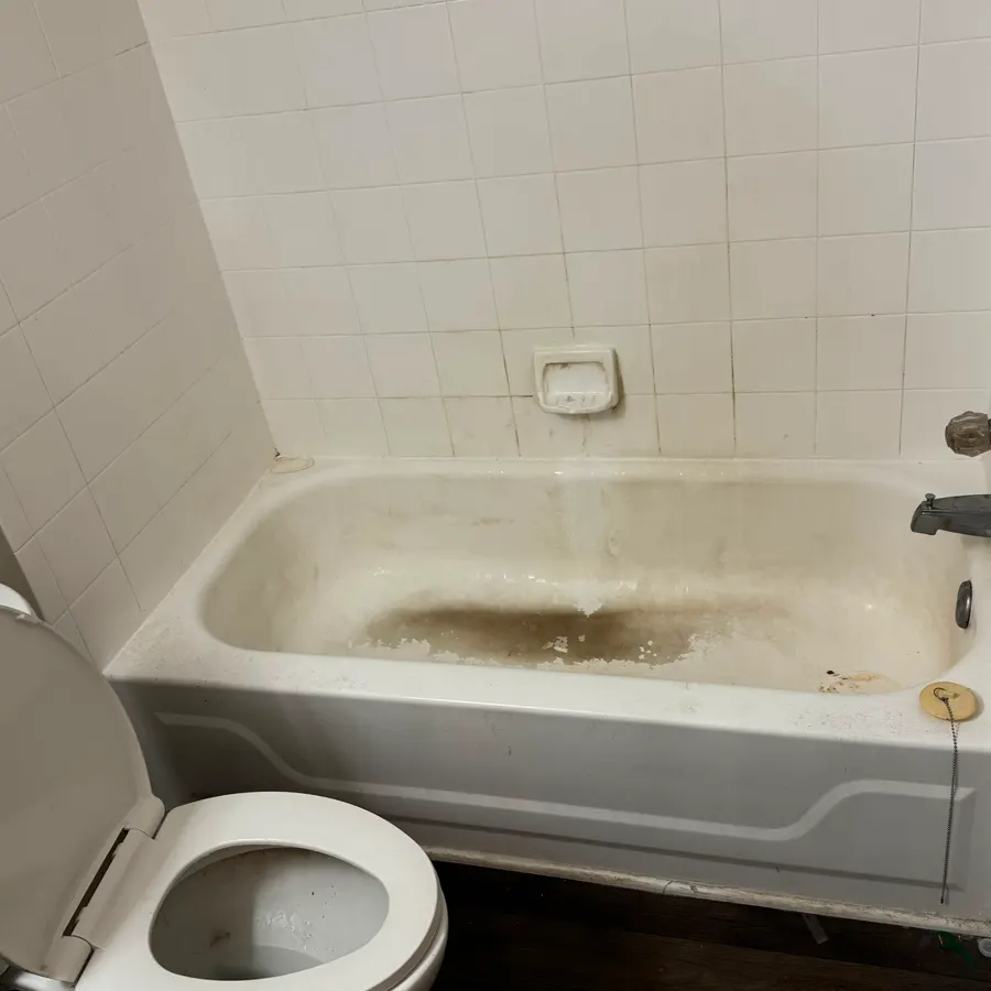 a bathtub and tiled surround, before a Brio Cleaning visit